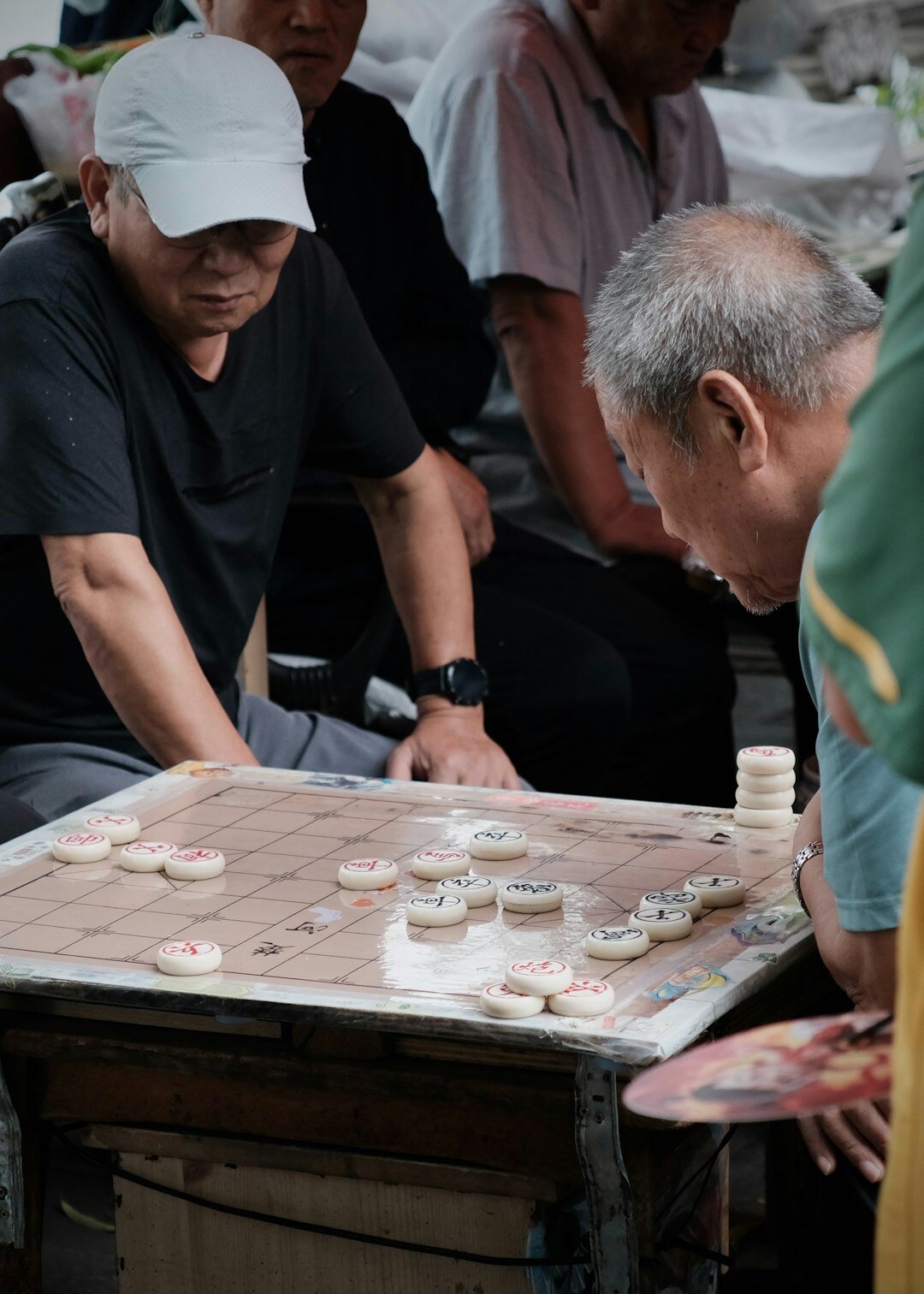 Elderly Japanese men playing a shogi board game together