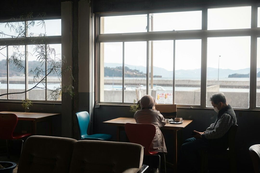 Elderly Japanese friends chatting and laughing over tea at a table