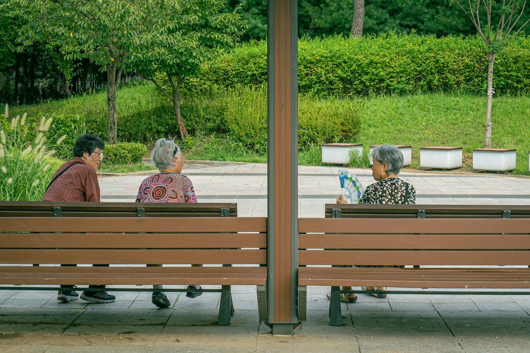 A Japanese senior couple reviewing a membership pamphlet with a staff member